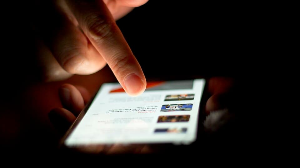 A hand scrolling on a smartphone screen, representing app setup on a mobile device