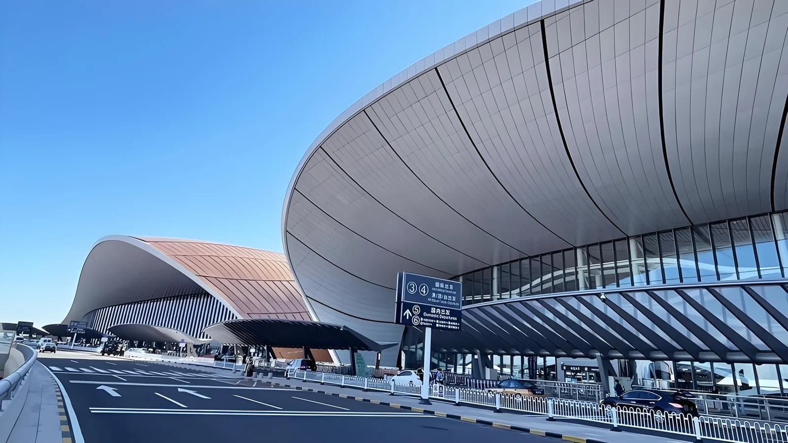 Illustrative image: Curving Daxing Airport terminal roof above the departure-level road