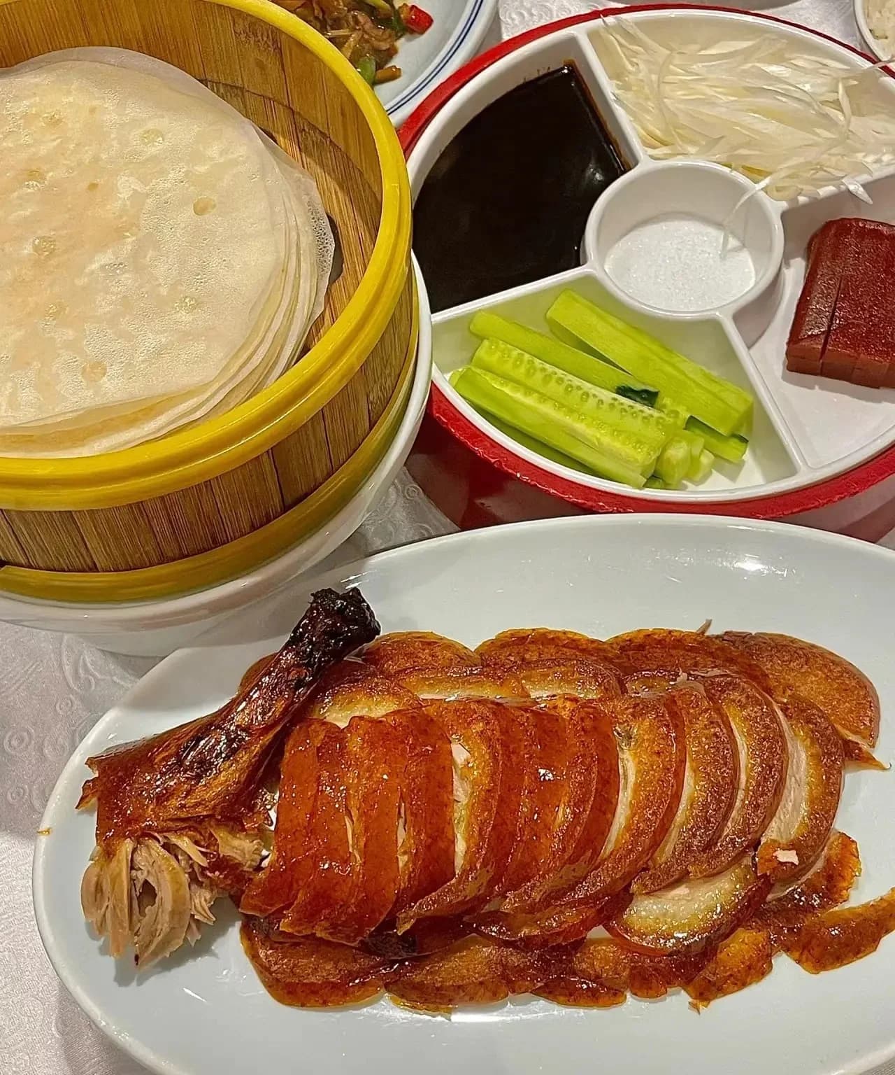 Sliced Beijing roast duck served with pancakes, cucumber and sauces
