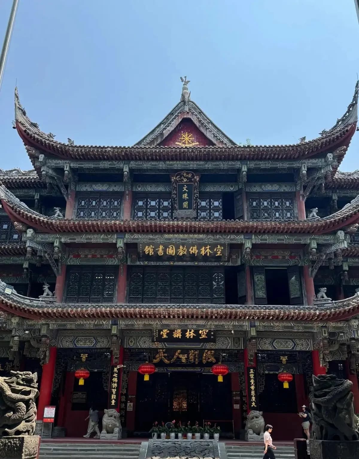 The ornate multi-storey Wenshu Pavilion at Wenshu Monastery, with carved woodwork and red lanterns.