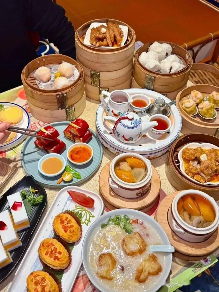 A table of dim sum in bamboo steamers, tea, congee and small dishes.