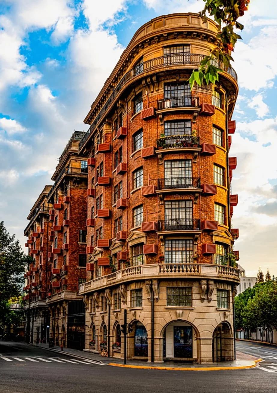 The narrow rounded corner of red-brick Wukang Mansion between two streets.