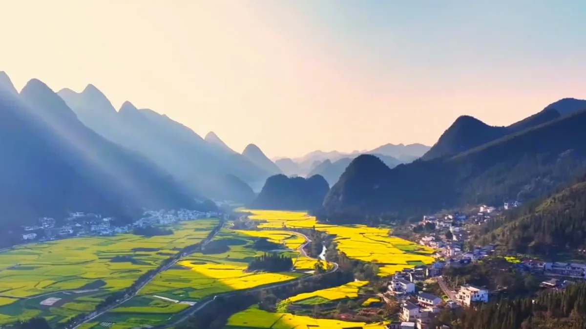 Green karst peaks rising above fields and villages in Wanfenglin, Guizhou